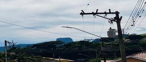 Una calle con edificios, líneas eléctricas y una montaña distante.