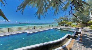 A pool with a view of the ocean and a distant island.