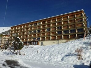 A multi-story hotel with a wooden facade and balconies.