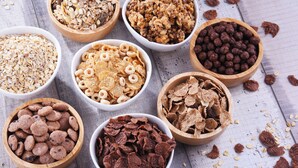 Various bowls of cereal and snacks on a wooden surface.