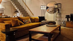 Un salon moderne avec un canapé, une table basse et un téléviseur.