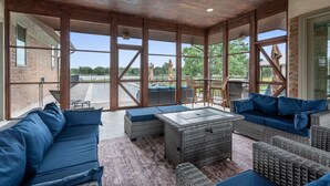A covered outdoor seating area with wicker furniture and a view of the backyard.