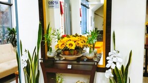 A reception desk with a mirror, potted plants, a small elephant figurine, and a flower arrangement. - HOTEL SOUL MATE INN  (Lima)