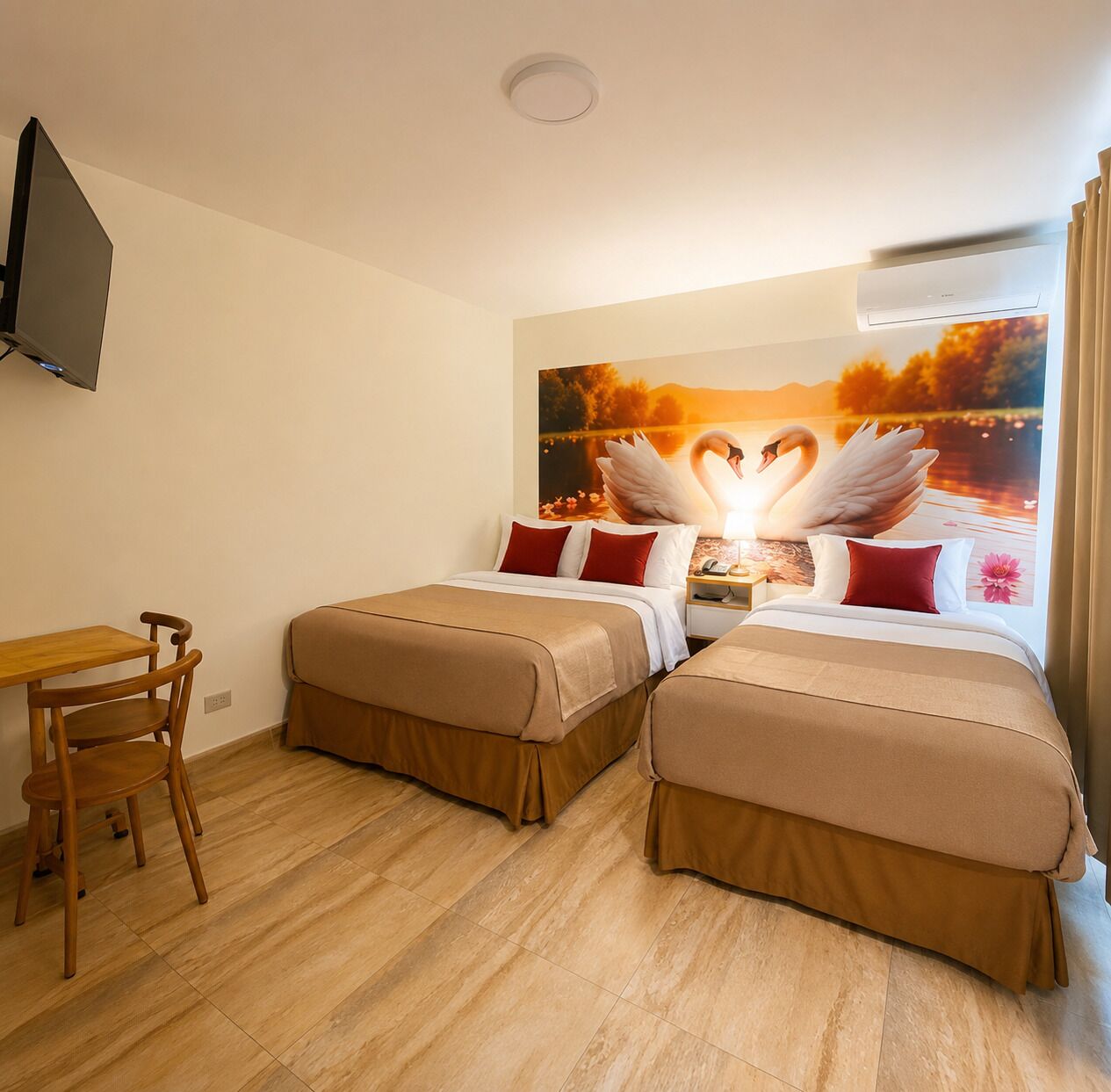 A hotel room with two beds, a desk, and a TV.