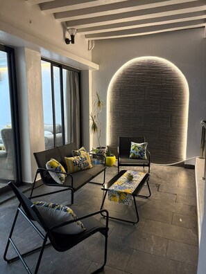 Una sala moderna con un ventanal grande, un elemento decorativo circular en la pared y una zona de estar con una mesa.
