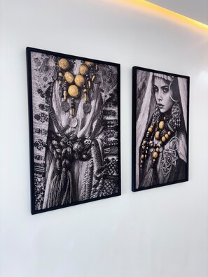 Duas obras de arte emolduradas numa parede.