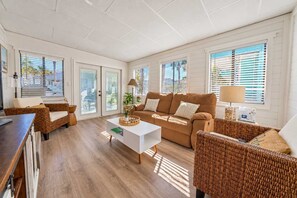 Un salón amplio con sofá, sillas, una mesa de centro y un comedor.
