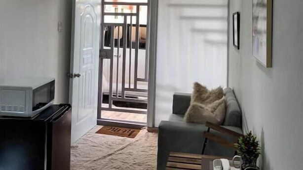 A modern living room with a sofa, a coffee table, and a television. - Apt Private +WiFi+AC+Kitchen @Dominican Republic (Santiago Province)