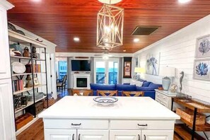 A kitchen with white cabinetry, a central island, and a hanging light fixture. - IP Beach House- Family Holiday home 3 bedroom sleeps 8, Friendly Ice Machine Southern Coast Vacation Properties (Port St. Joe)