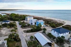 Una propiedad costera con varias edificaciones, un camino y una playa.