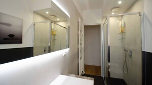 A modern bathroom with a large mirror, a shower enclosure, and a white sink. - Family apartment in the center of Pisa - Design LM House (Pisa)