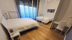 A bedroom with a bed, bedside table, and a mirror. - Family apartment in the center of Pisa - Design LM House (Pisa)