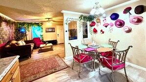 A dining area with a chandelier, a table with chairs, and a wall decorated with hats. - Bohemian Home•King Bed•Long Stay•RV/Boat/Trailer Parking•RenFest (Magnolia)