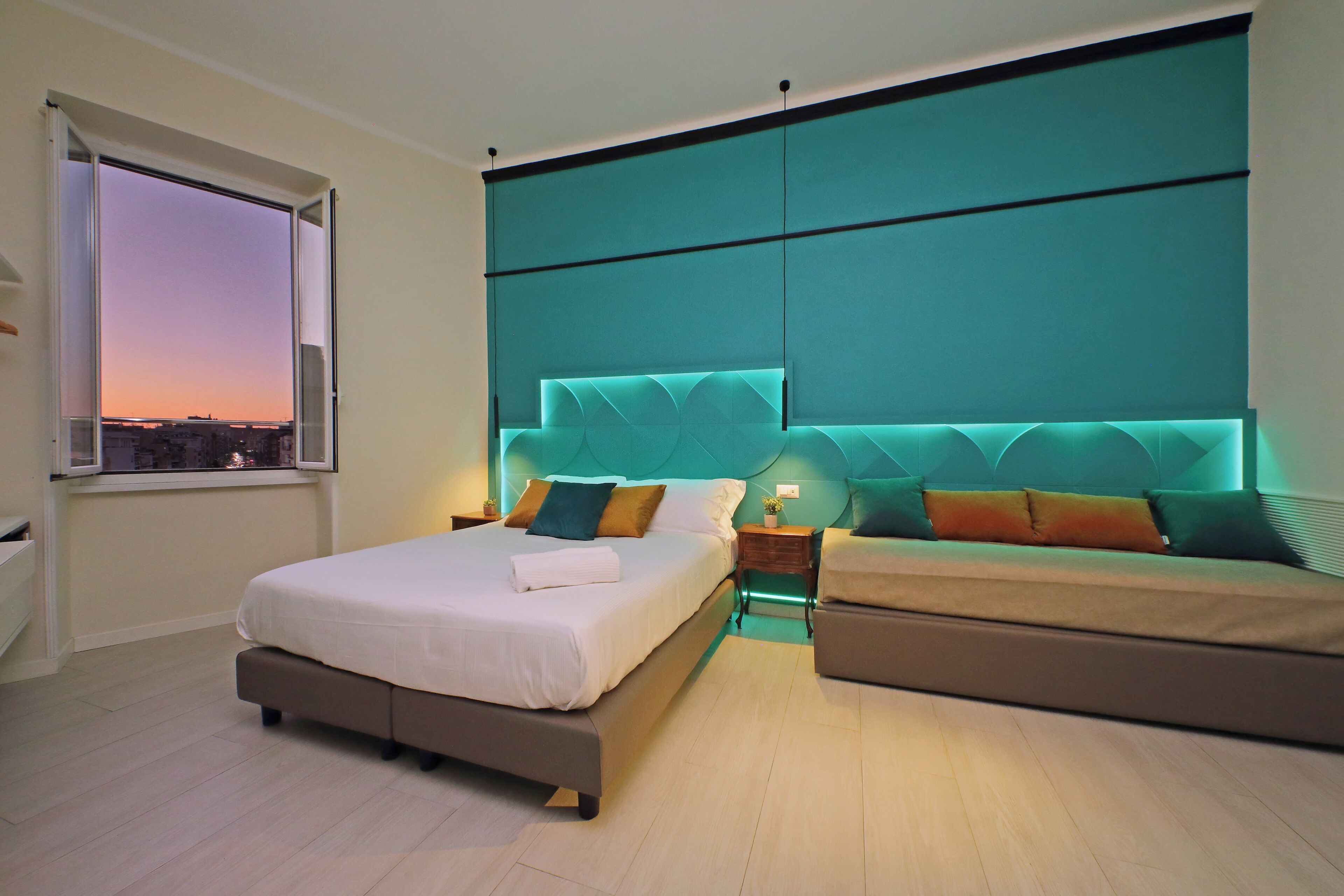 Une chambre moderne avec un lit, un canapé et une vue sur la ville par la fenêtre.