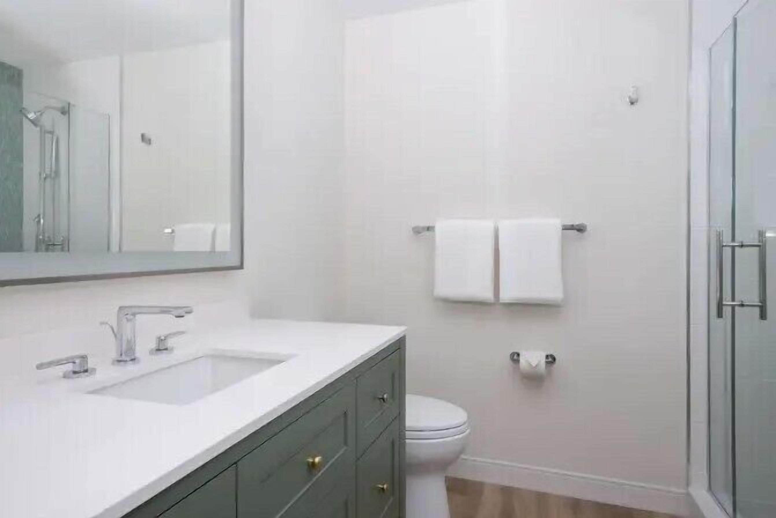 Une salle de bain moderne avec un lavabo, un meuble-lavabo et des toilettes, le tout de couleur blanche.