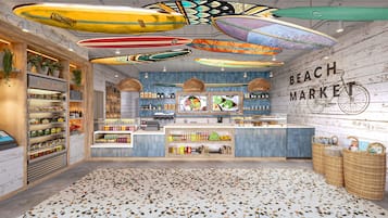 A beach-themed cafe with surfboards hanging from the ceiling, a 'BEACH MARKET' sign, and a variety of food and drink items displayed.
