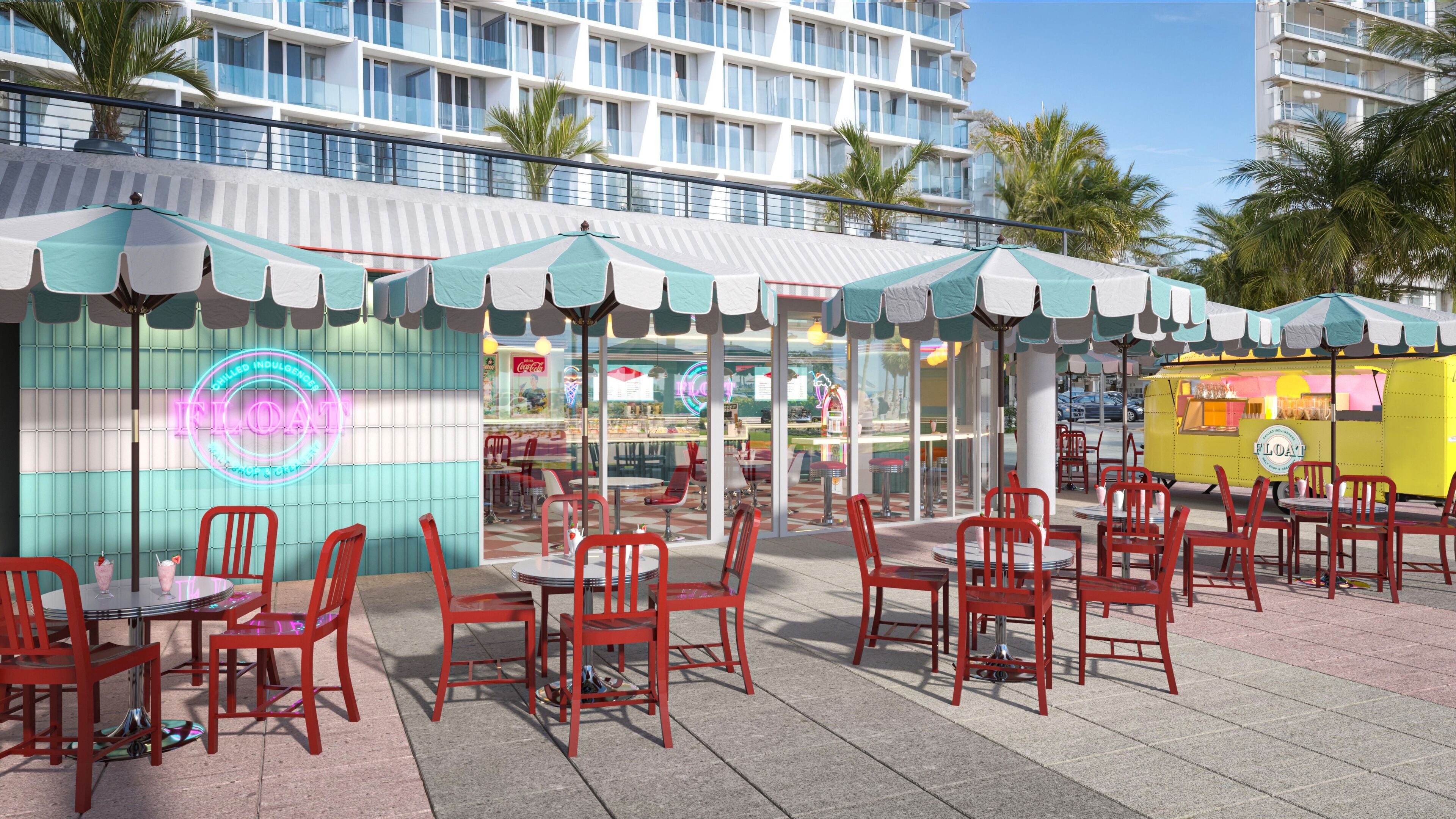 An outdoor café with red chairs and tables, a neon sign, and a building in the background.