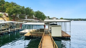 A dock with a covered seating area, a small shed, and a pool. - Your Lake Escape Awaits! – 3BR/2BA with Private Dock in a Fun Cove at 2MM (Lake Ozark)