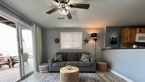 A living room with a grey sofa, a round coffee table, and a ceiling fan. - Your Lake Escape Awaits! – 3BR/2BA with Private Dock in a Fun Cove at 2MM (Lake Ozark)