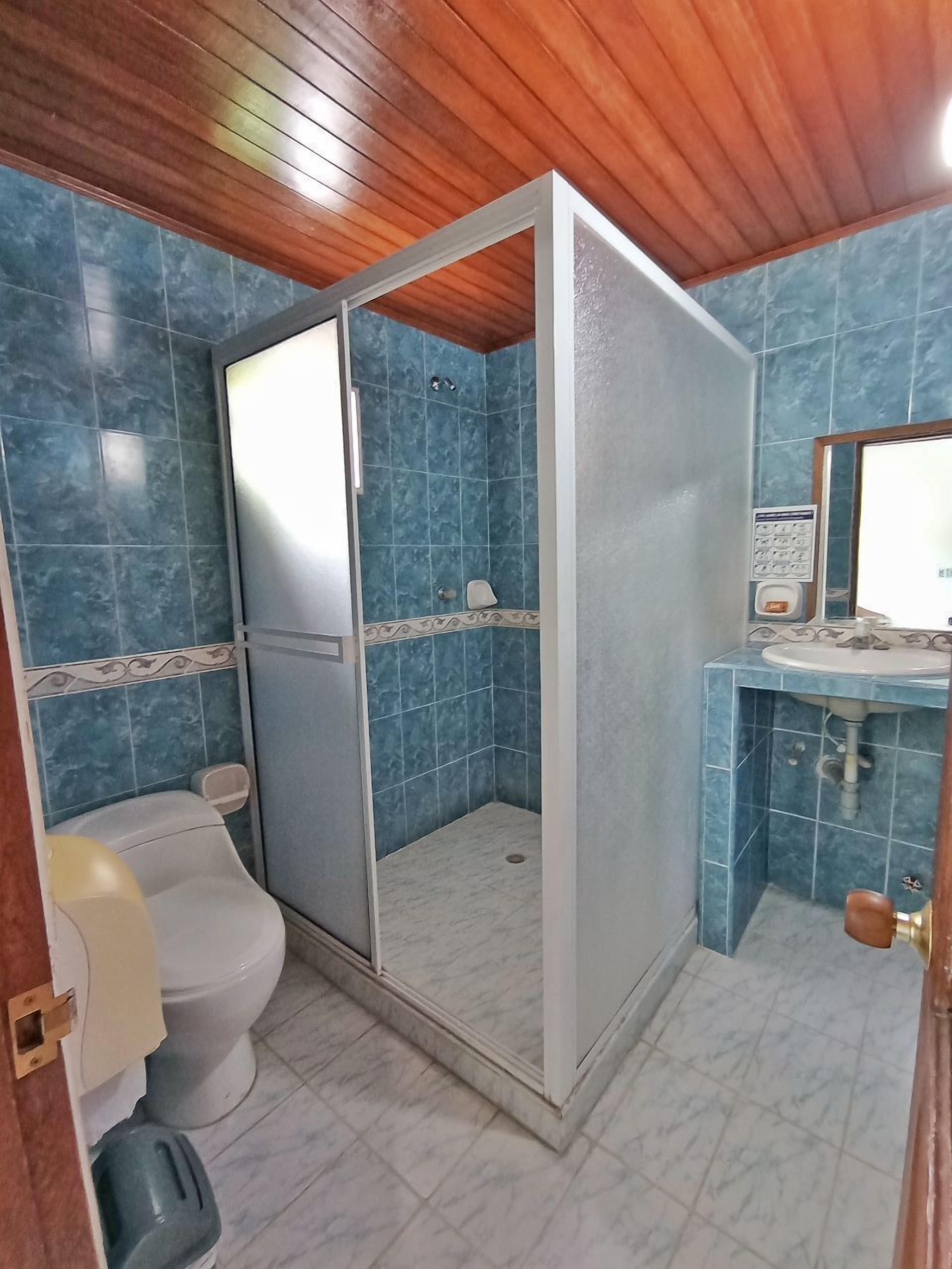 Ein Badezimmer mit Dusche, Toilette und Waschbecken.
