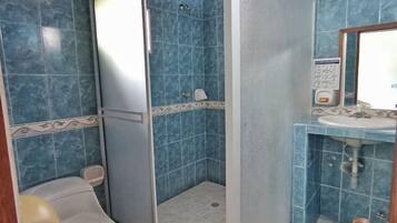 Ein Badezimmer mit Dusche, Toilette und Waschbecken.