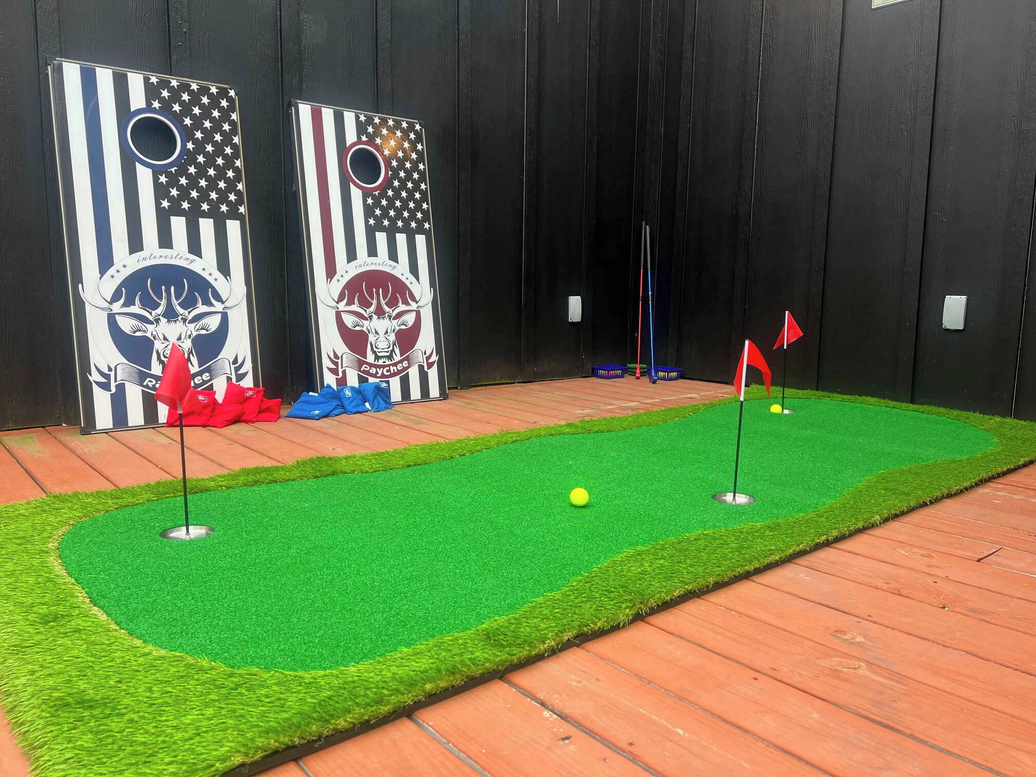 Een midgetgolfbaan met twee grote doelpalen in het thema van de Amerikaanse vlag, een rode vlag en een golfbal op een groen kunstgrasveld.