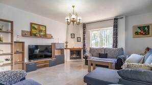 Una sala de estar moderna con chimenea, televisor y sofá.