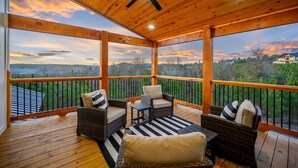 A covered outdoor deck with wicker furniture and a ceiling fan. - New, Modern, Bunk Room, Game Room, Playground, Hot tub (Broken Bow)