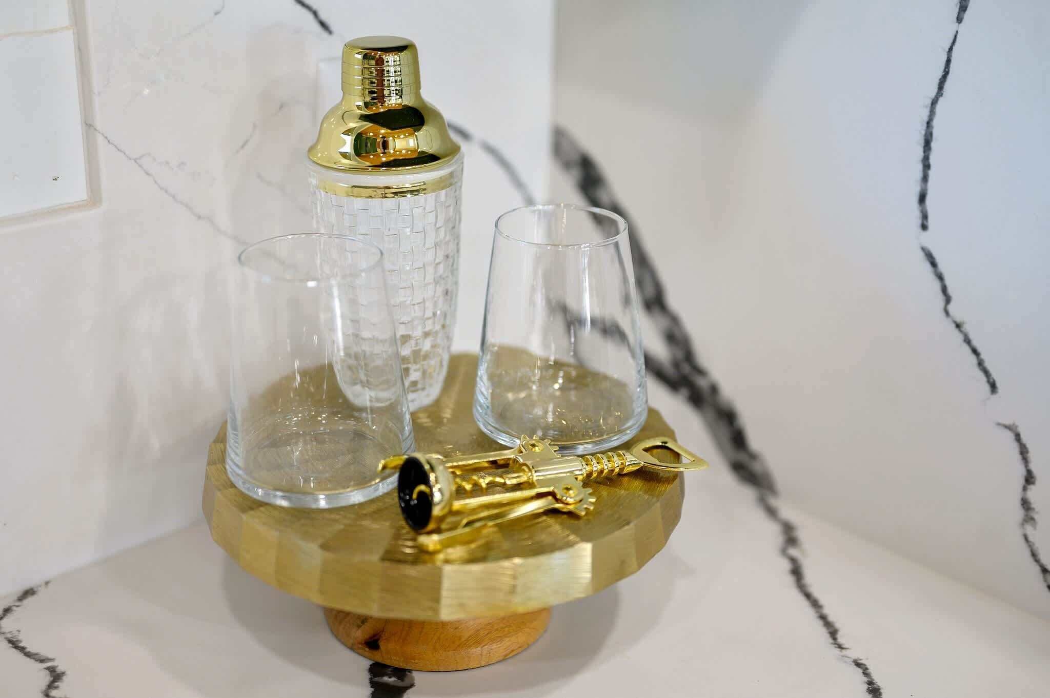 A decorative glass key holder with a gold-colored key on a wooden base.