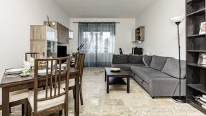 A modern living room with a dining table, sofa, and bookshelf.
