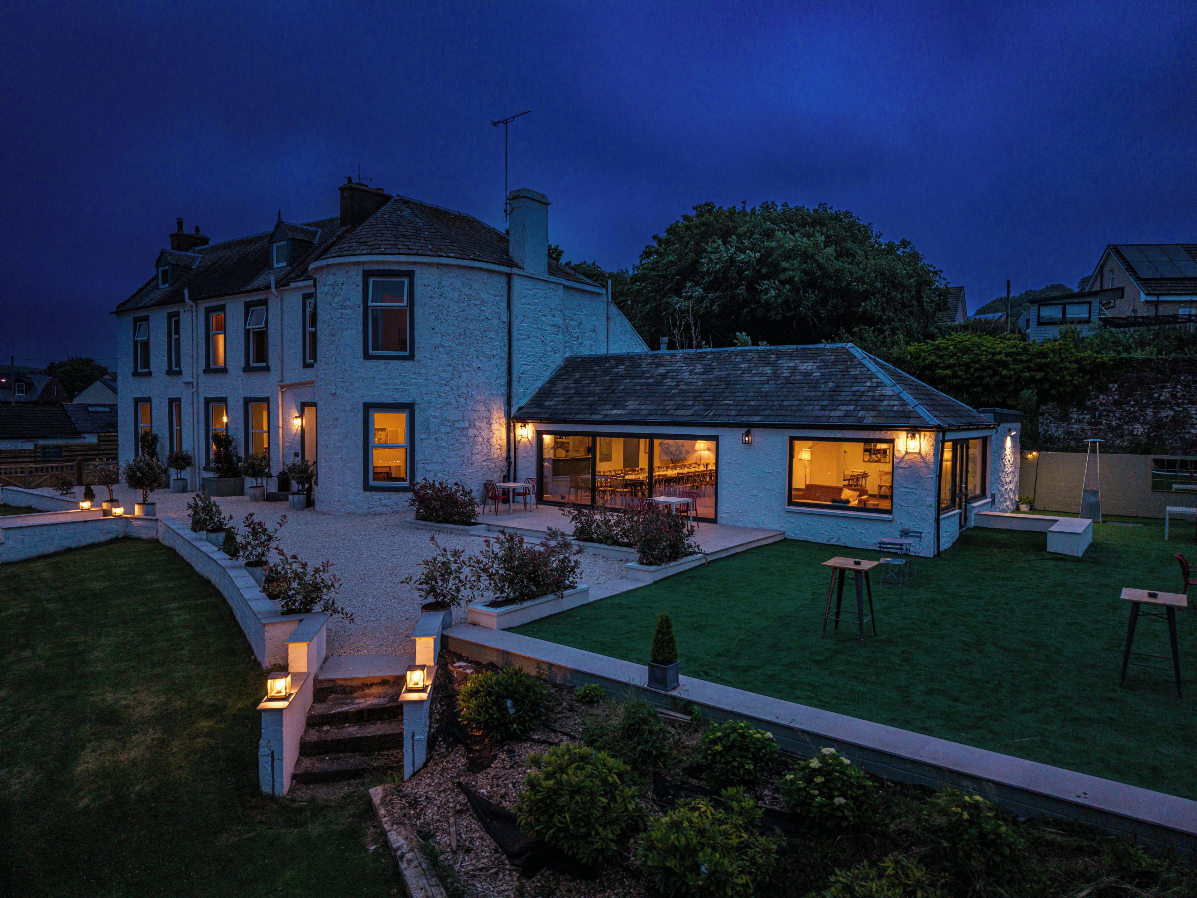 A two-story house with a well-maintained lawn and outdoor seating area.