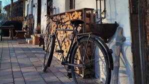 Una bicicletta parcheggiata di fronte a un edificio con tetto in legno e parete esterna bianca.