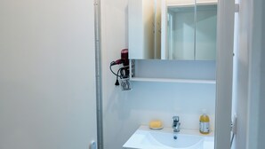 Ein Badezimmer mit Waschbecken, Spiegel und Handtuchhalter.
