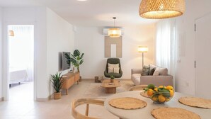 A modern living room with a sofa, coffee table, and a dining area with a table and chairs. - Villa Leyni Torrox by Ruralidays (Málaga)