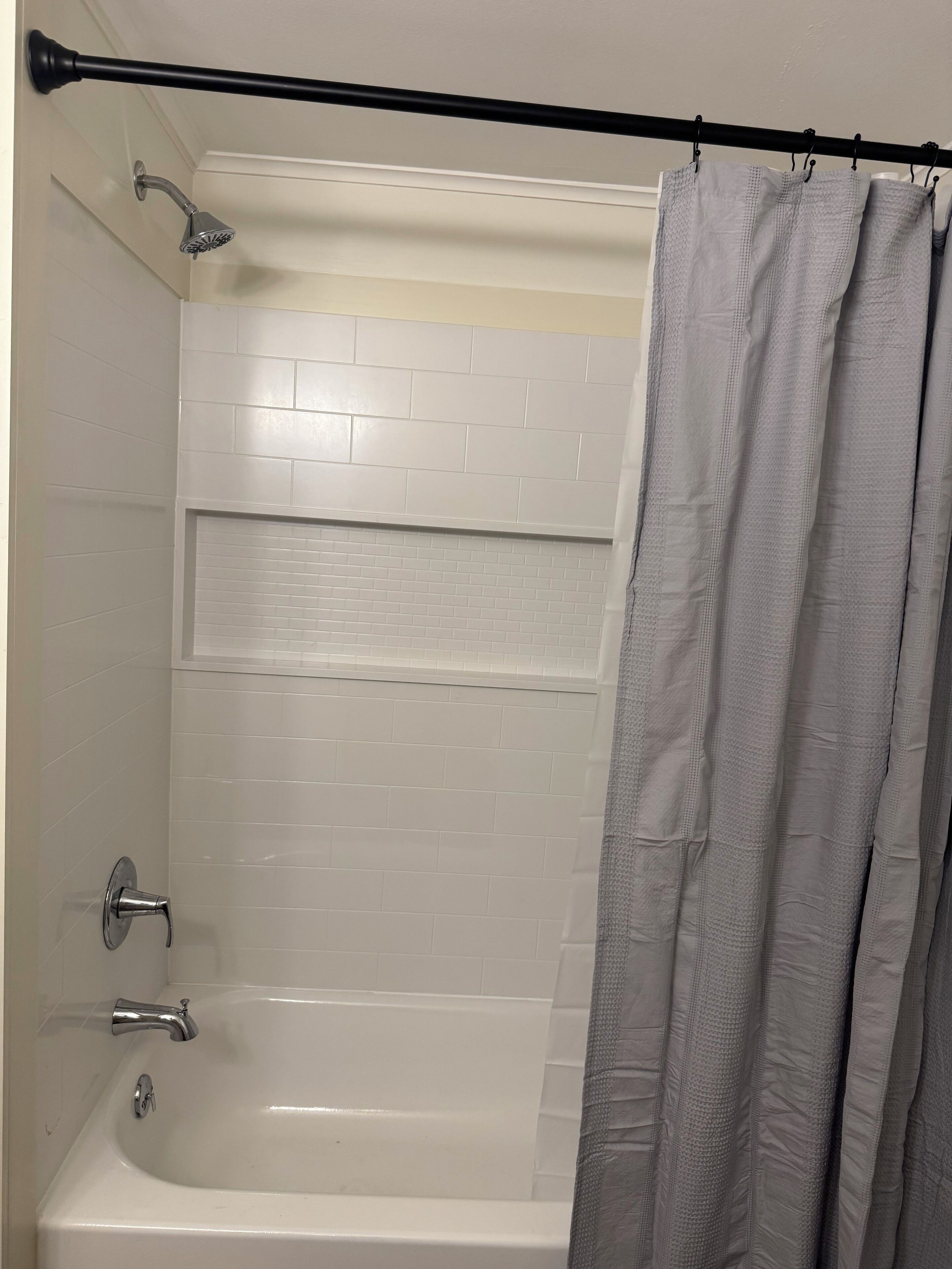 Ein Badezimmer mit Badewanne, Dusche und Handtuchhalter.