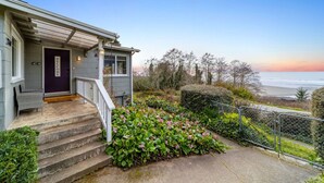 A house with a welcoming front door, a porch with steps, and a view of the ocean. - Gog and Pop's Beach House - Ocean Views, WiFi, BBQ (Trinidad)