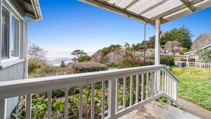 A coastal house with a covered porch, a garden with various plants, and a view of the ocean. - Gog and Pop's Beach House - Ocean Views, WiFi, BBQ (Trinidad)