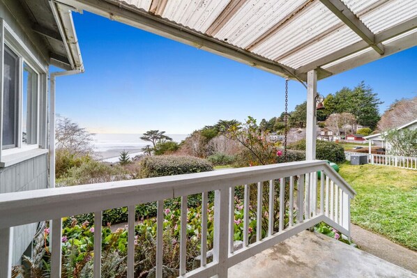 A coastal house with a covered porch, a garden with various plants, and a view of the ocean. - Gog and Pop's Beach House - Ocean Views, WiFi, BBQ (Trinidad)