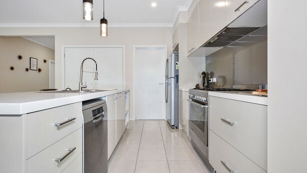 A modern kitchen with white cabinetry, stainless steel appliances, and pendant lighting. - Point Cook Serenity Stay (Point Cook)