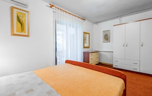 A bedroom with a bed, a desk, a wardrobe, and two framed pictures on the wall. - Lovely apartment in Porec with WiFi (Porec)
