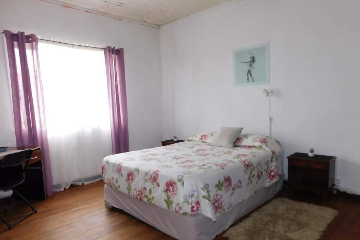 Una camera da letto con un letto, una scrivania e una sedia.