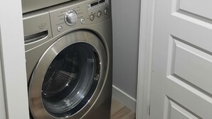 Un lavadero pequeño con dos lavadoras apiladas de carga frontal.
