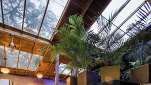 A staircase with a metal handrail, leading to a seating area with chairs and a table. - Park Lleras 11br Pool Jacuzzi (Medellín)