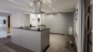 A modern kitchen with a central island, stainless steel appliances, and a minimalist design.