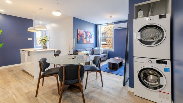 Un apartamento moderno con zona de comedor, cocina y sala de estar. Cuenta con lavadora y un ventanal grande.