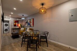 A compact living space with a dining area, a sofa, a coffee table, and a hanging light fixture. - Beautiful 3BR in Plateau Mont-Royal (Montréal)