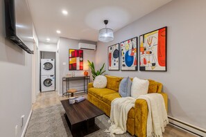 A modern living room with a sofa, a coffee table, and artwork on the wall. - Beautiful 3BR in Plateau Mont-Royal (Montréal)