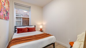 A bedroom with a bed, a window, a nightstand, and a chair. - Stylish 3BR/2BA in the Plateau (Montréal)