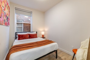 A bedroom with a bed, a window, a nightstand, and a chair. - Stylish 3BR/2BA in the Plateau (Montréal)