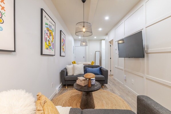 A modern living room with a sofa, a coffee table, and artwork on the walls. - Stylish 3BR/2BA in the Plateau (Montréal)